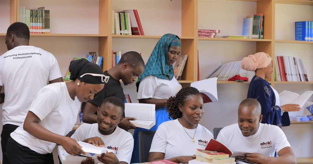 AIHS students and staff, wearing Ahaki Institute shirts, reading together in the institute library