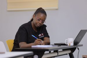 AIHS student taking notes with a laptop on campus
